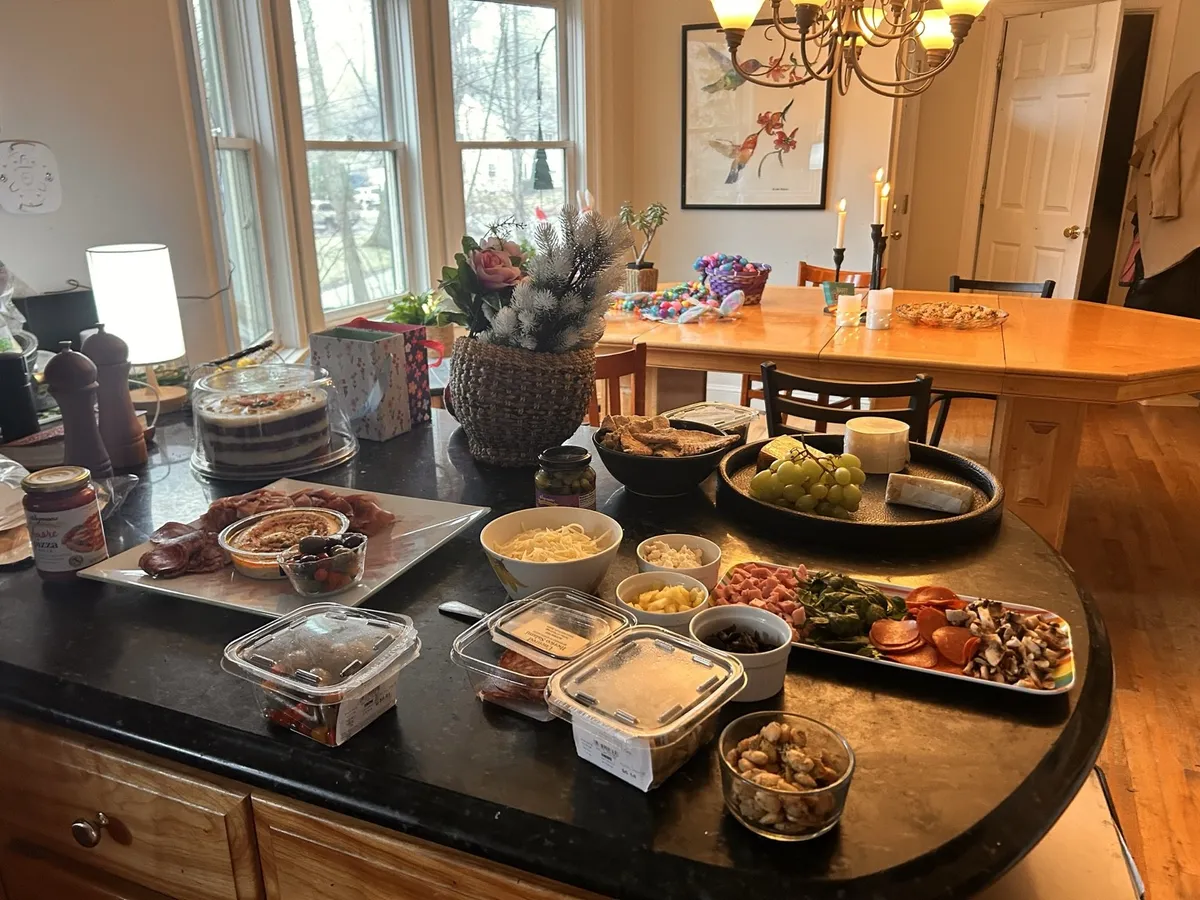 A catered brunch laid out on the kitchen island and the handmade dining table