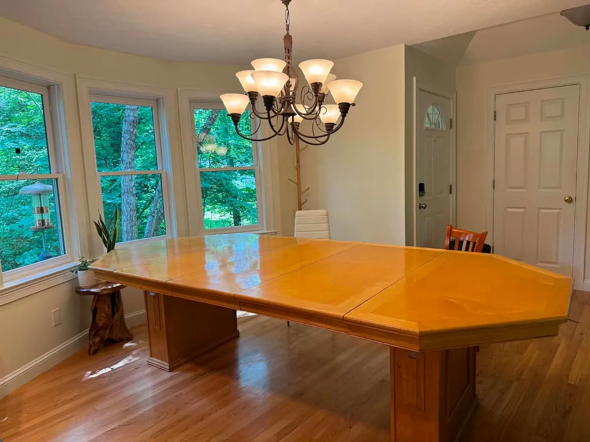 The handmade octagonal dining table under a chandelier